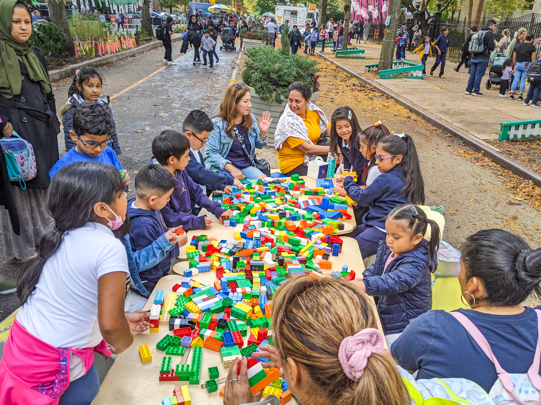 Children playing with blocks on the table on the street.