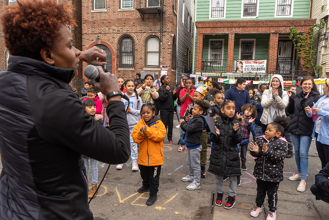 a teacher leading a group of elementary school students in an exercise session in the street