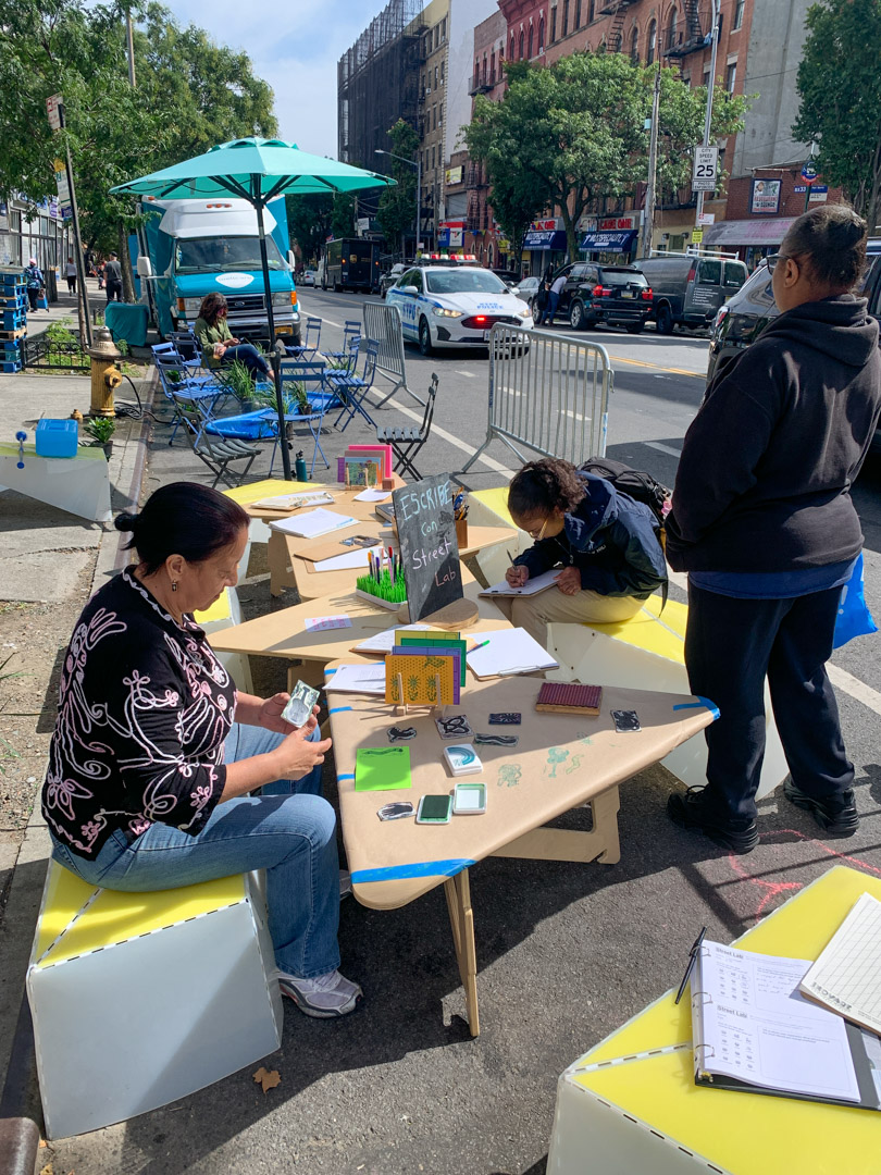 a wooden board with photos and notes (written by elementary students) on what they want to see on their street