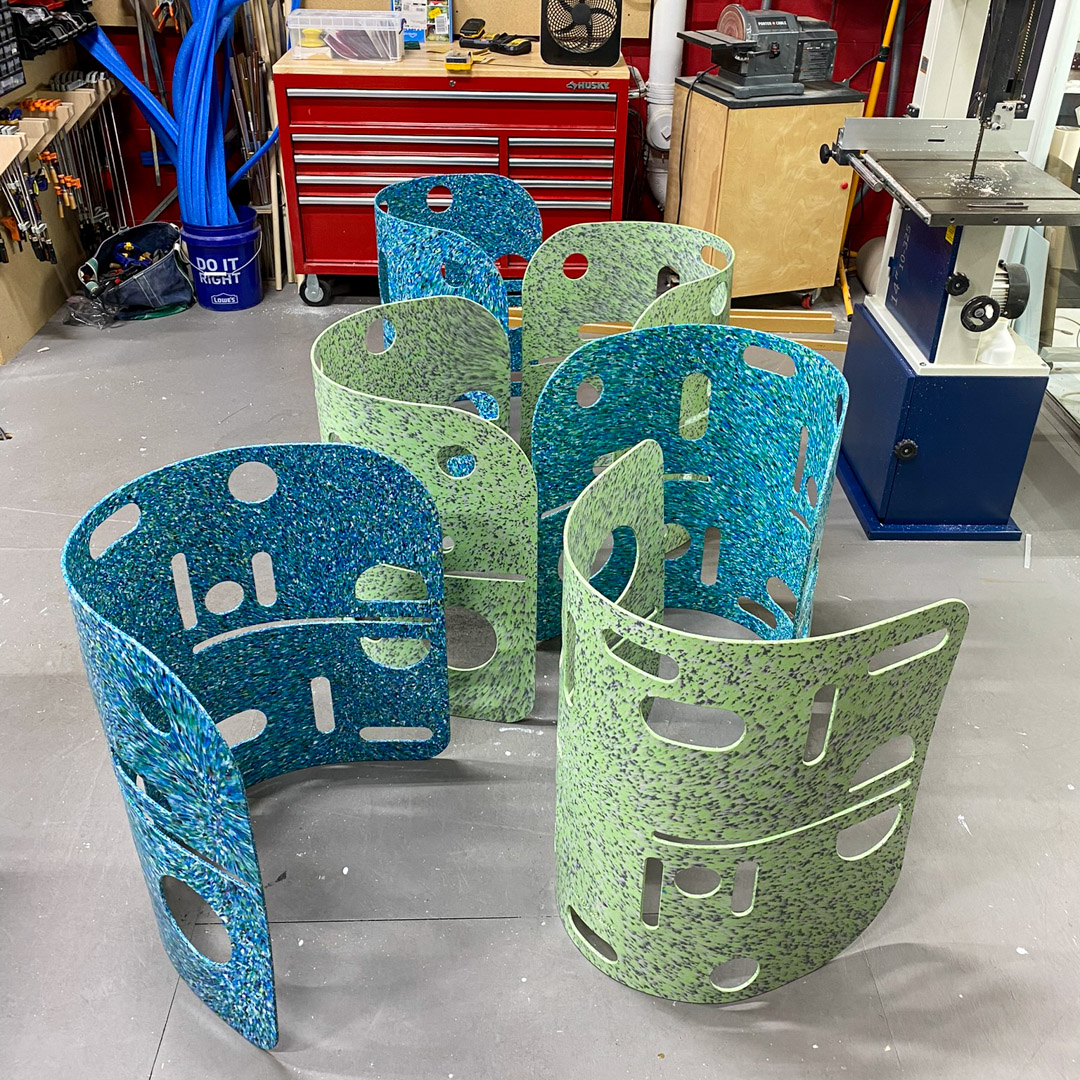 a photograph of shell chairs made out of recycled plastic in a fabrication studio