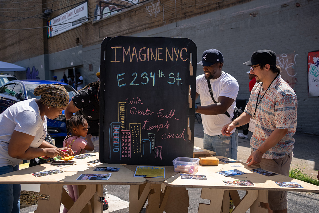 Group of people engaging in a community engagement activity. The signage reads "IMAGINE NYC E 234th St"