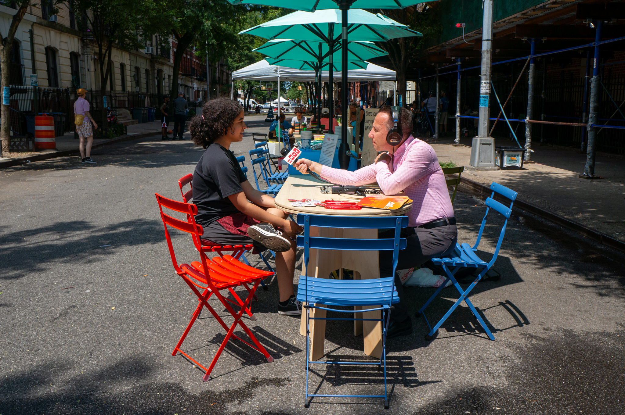 A man holding a mic to the woman across the table from him.