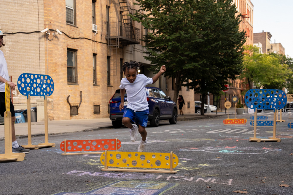 People drawing on an One Big Table by an organization Street Lab at an open street in NYC.