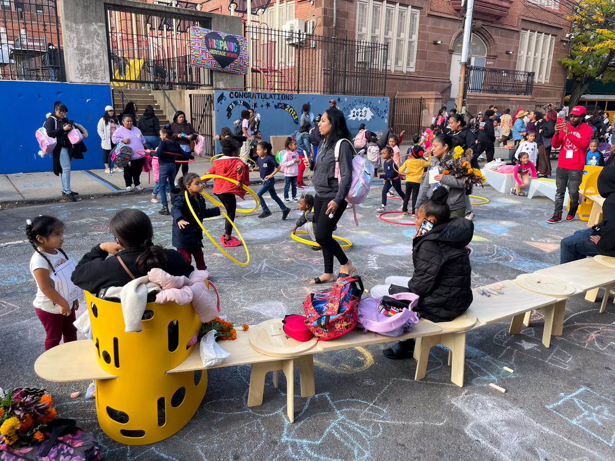 A boy jumping a hurdle on a street in NYC.