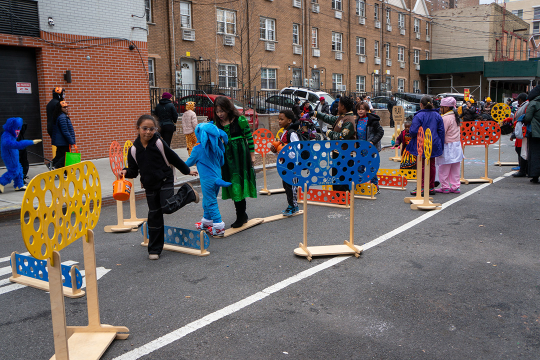 A group of kids jumping on hurdles on an open street in NYC.