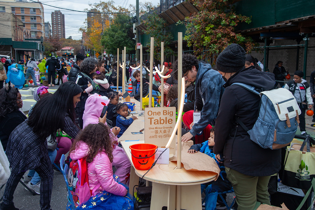 People drawing on an One Big Table by Street Lab at an open street in NYC.