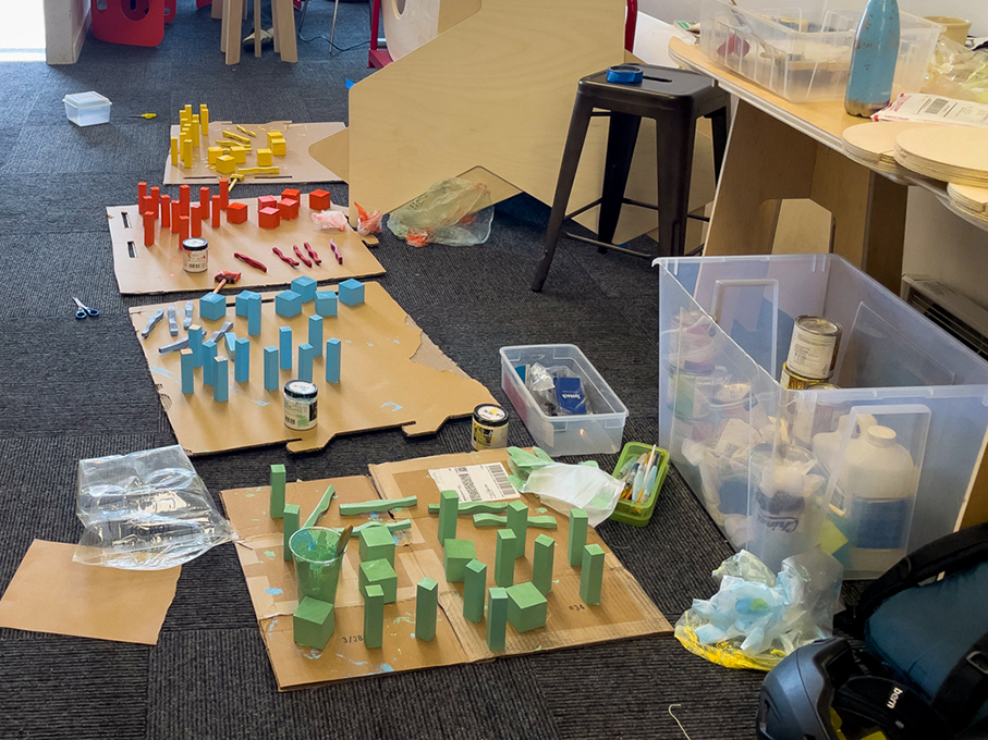 A messy floor with different colored blocks and tools.