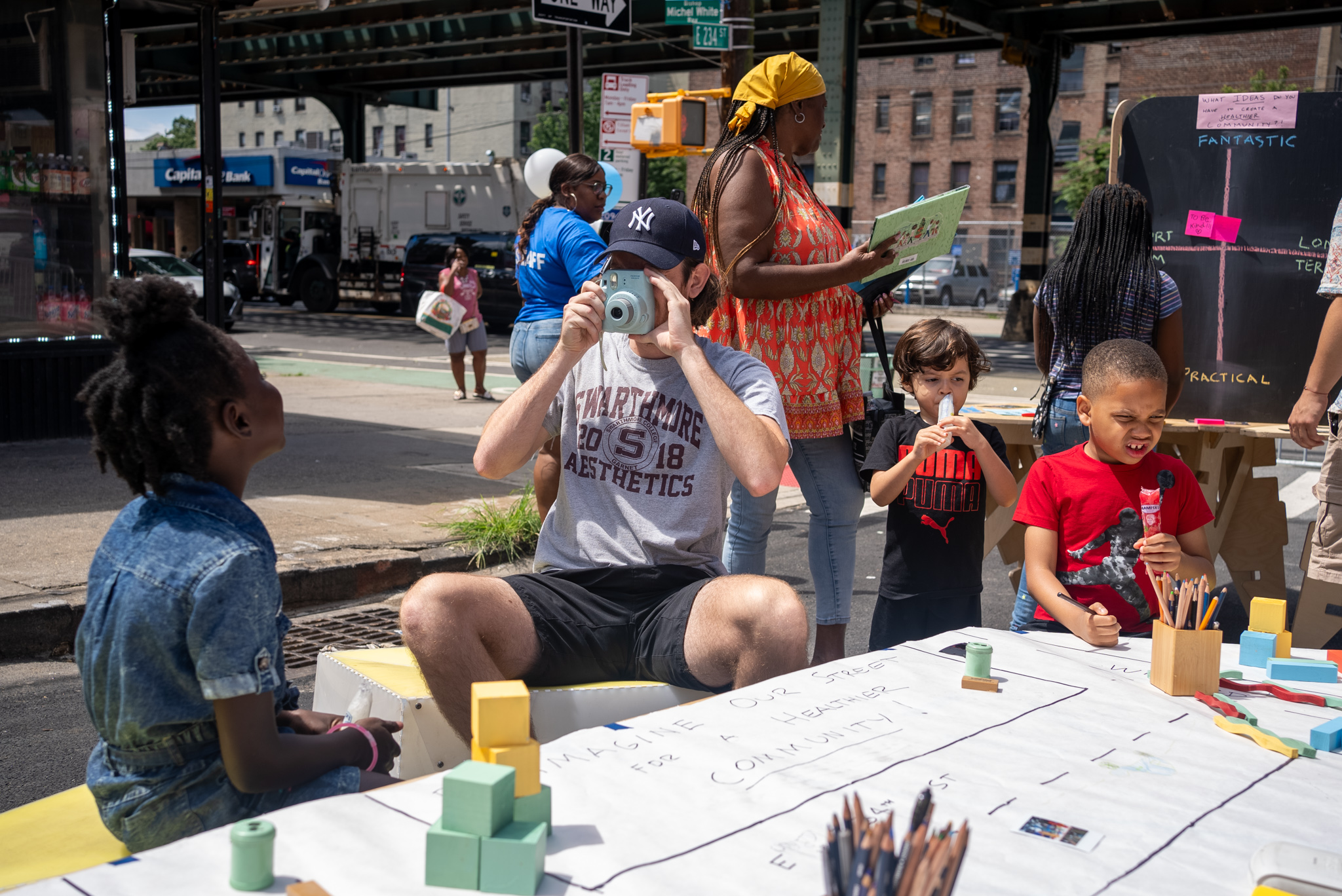 A man taking a polaroid photo of a girl in the NYC street.