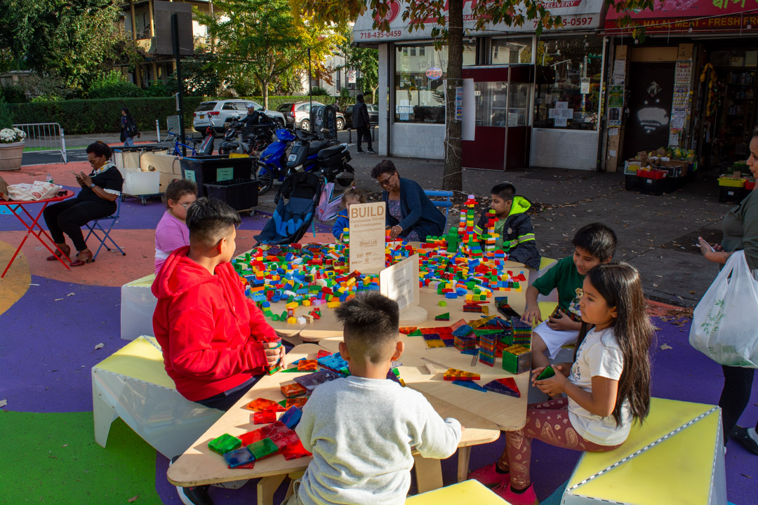 Children playing with lego blocks and Magnatiles on the street.