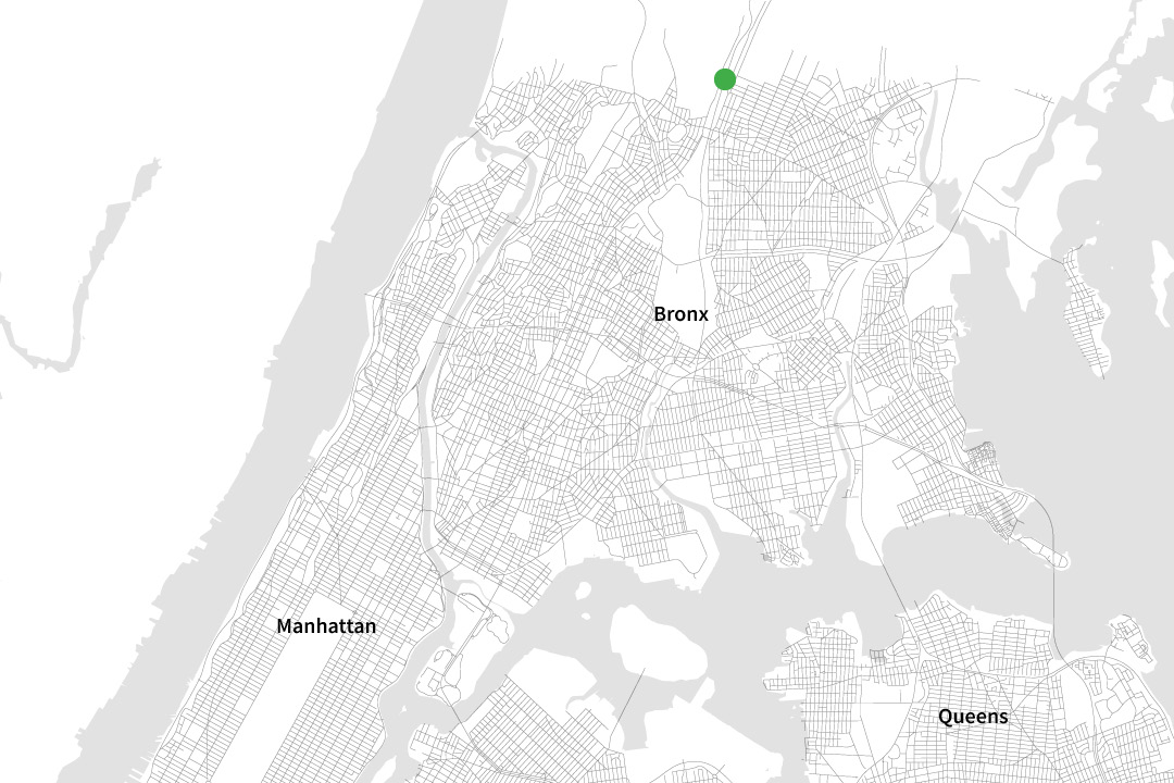 A black and white map of NYC zoomed in to only see some parts of the "Bronx," "Manhattan," and "Queens" with a green dot on a street in the Bronx.