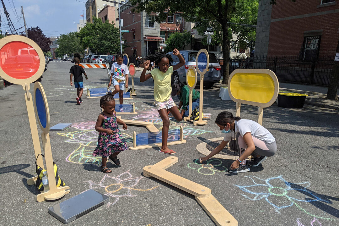 A group of children playing and chalking on the street of NYC.