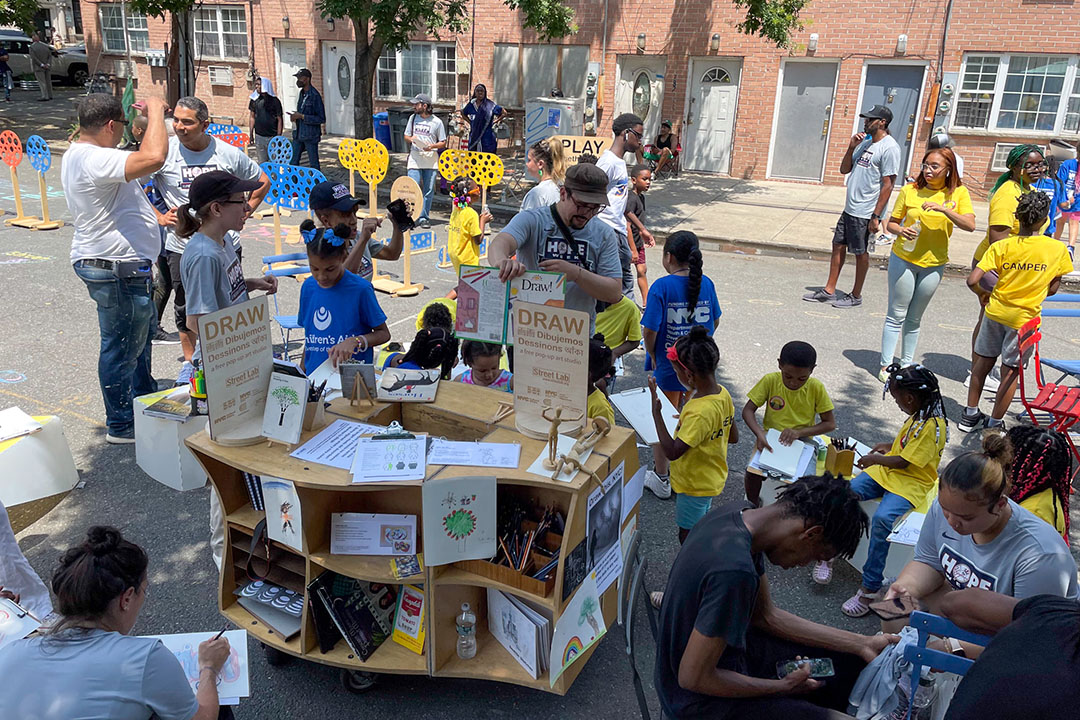 Children and adults drawing on the street.