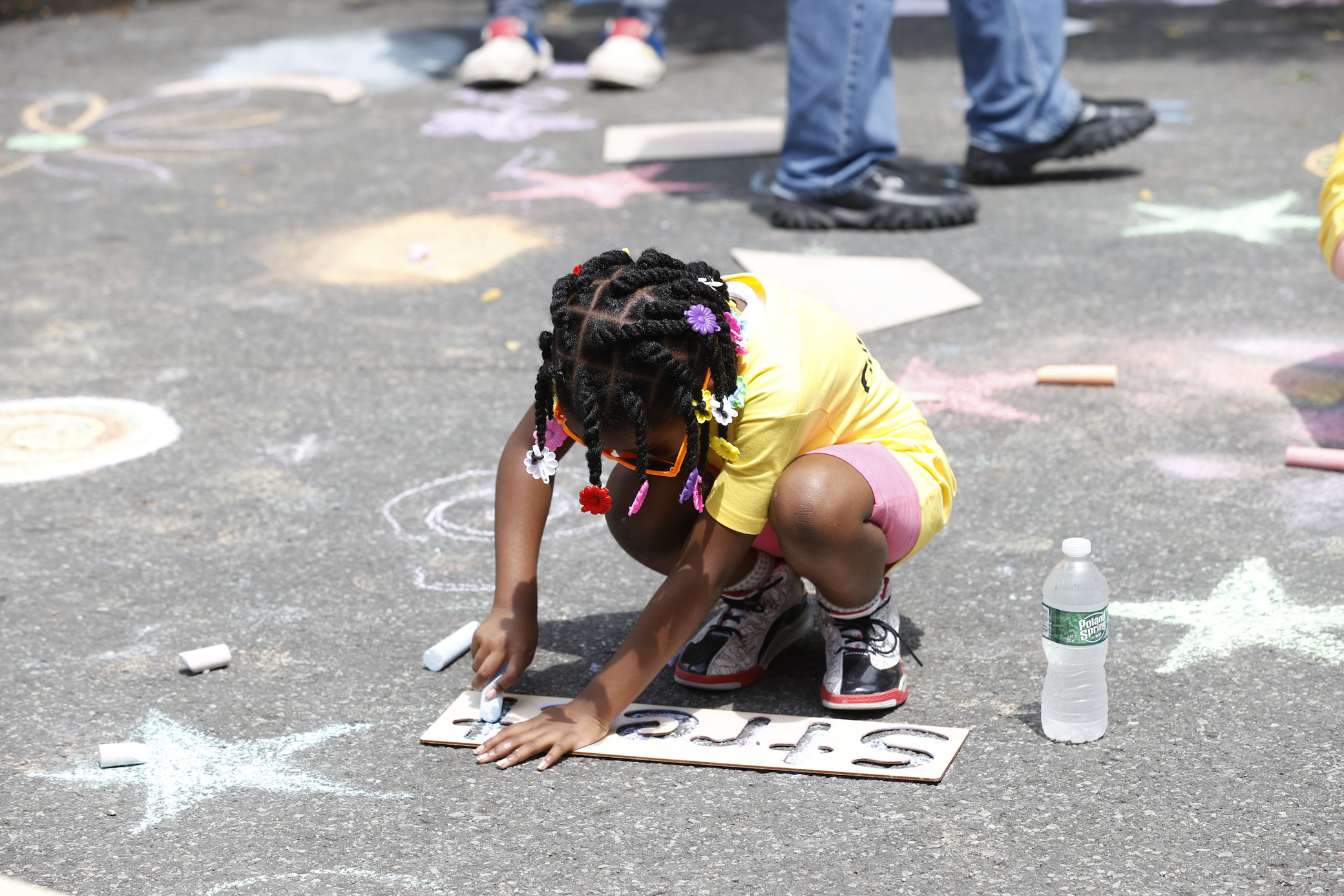 A child chalking on the street.