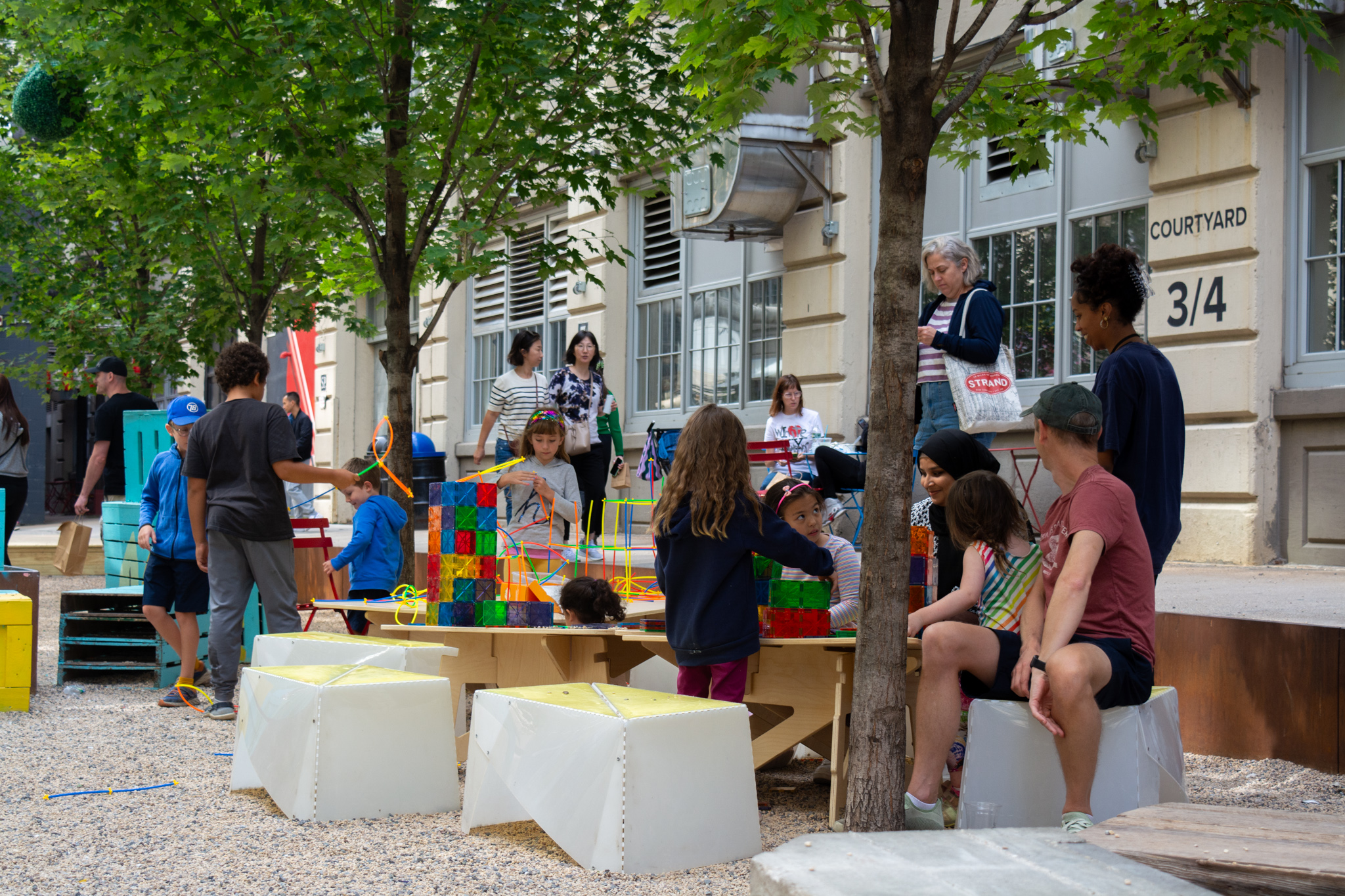 Group of people engaging in a community engagement activity. The signage reads "IMAGINE NYC E 234th St"