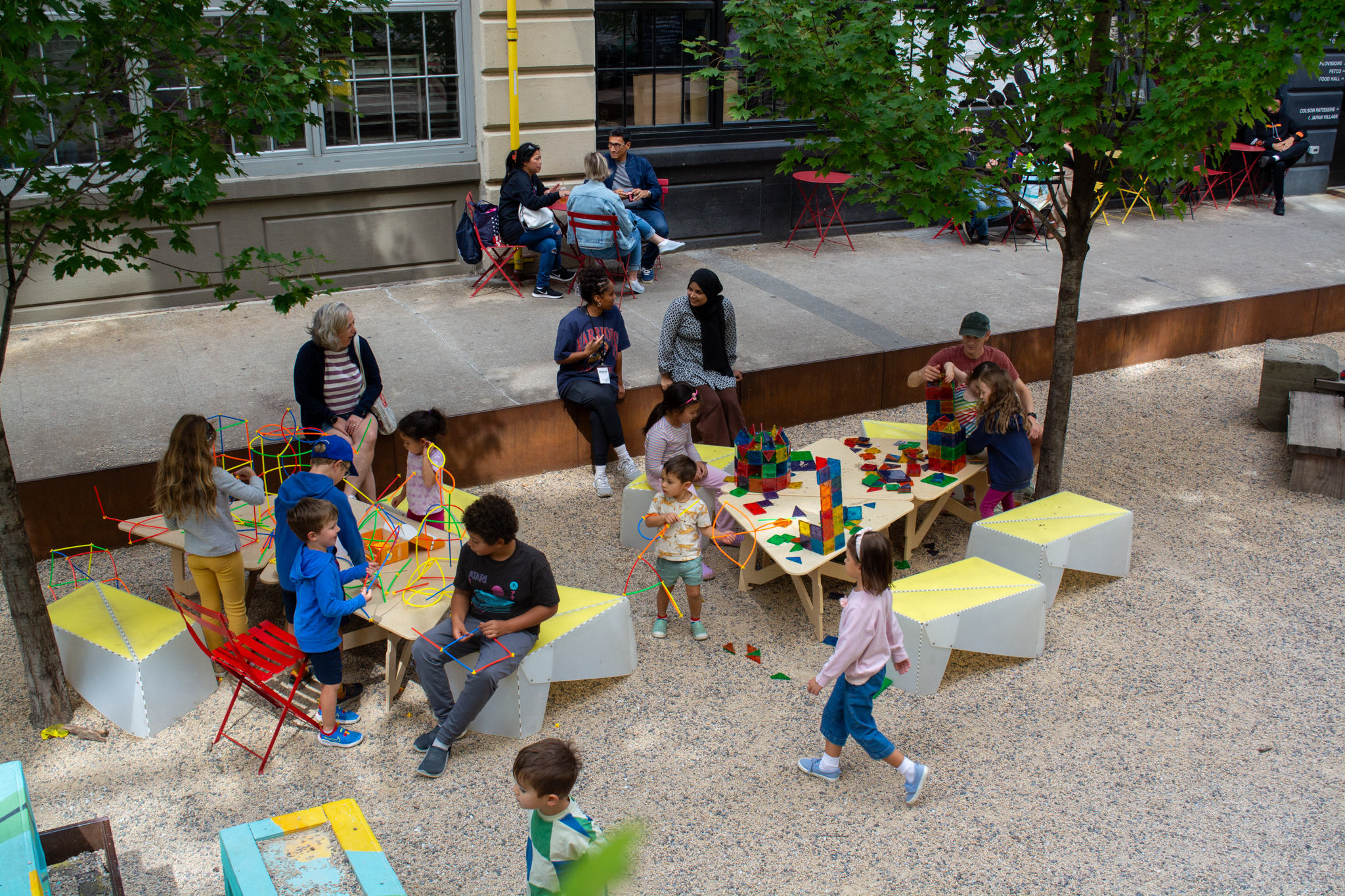 A view of children playing in an outdoor area of a food hall. 