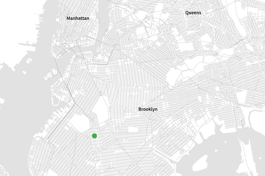 A black and white map of NYC zoomed in to only see some parts of "Manhattan," "Queens" and "Brooklyn" with a green dot on a street in Brooklyn.