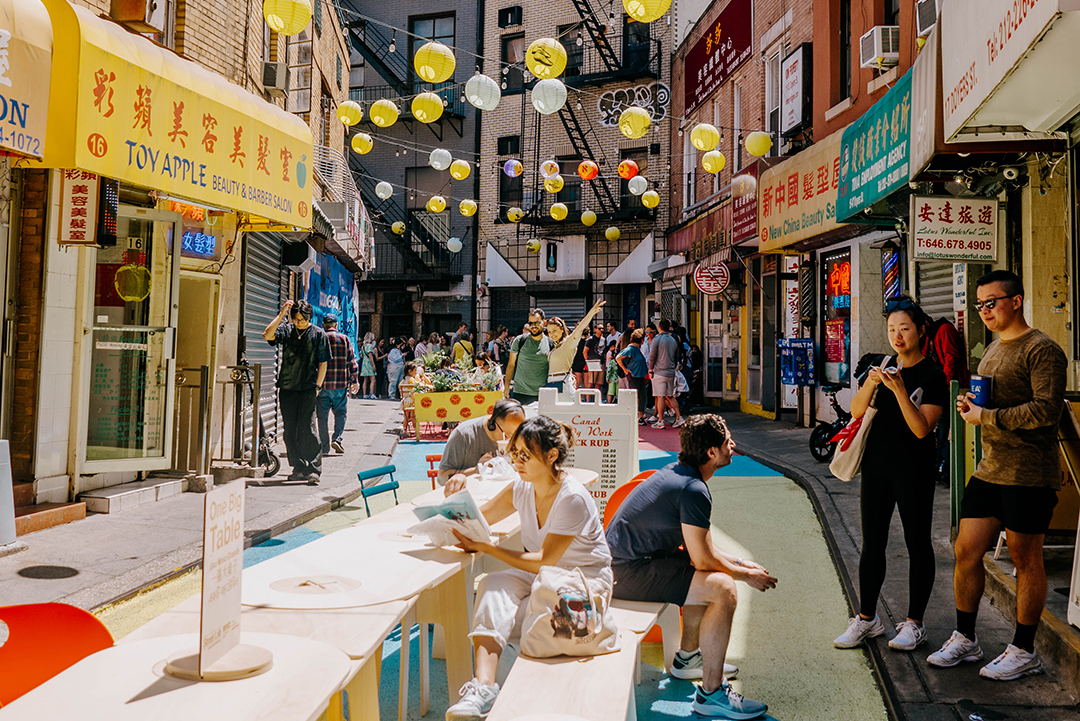 People gathered around one big table on the street.