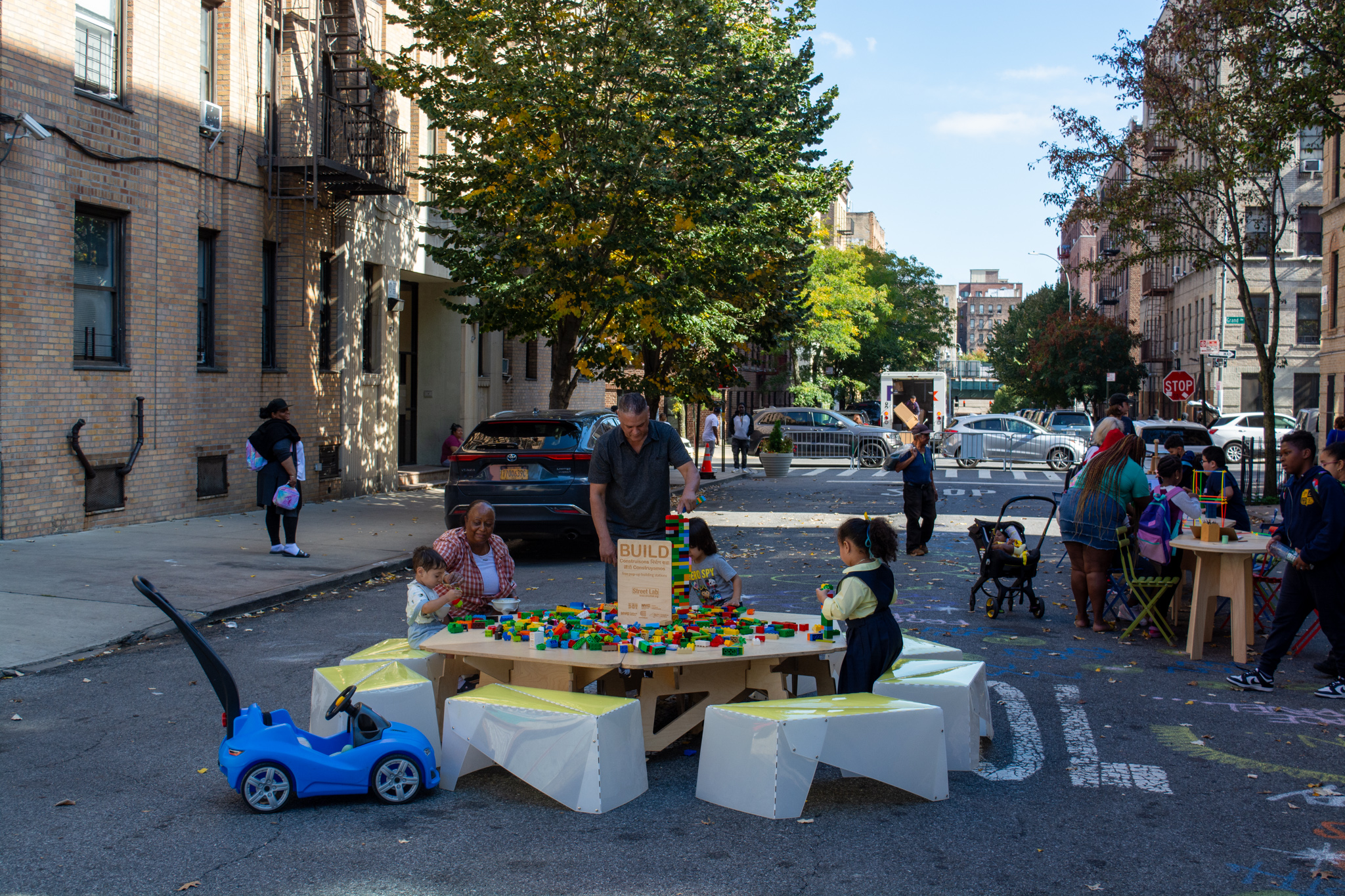 A view of kids playing with blocks on the street.