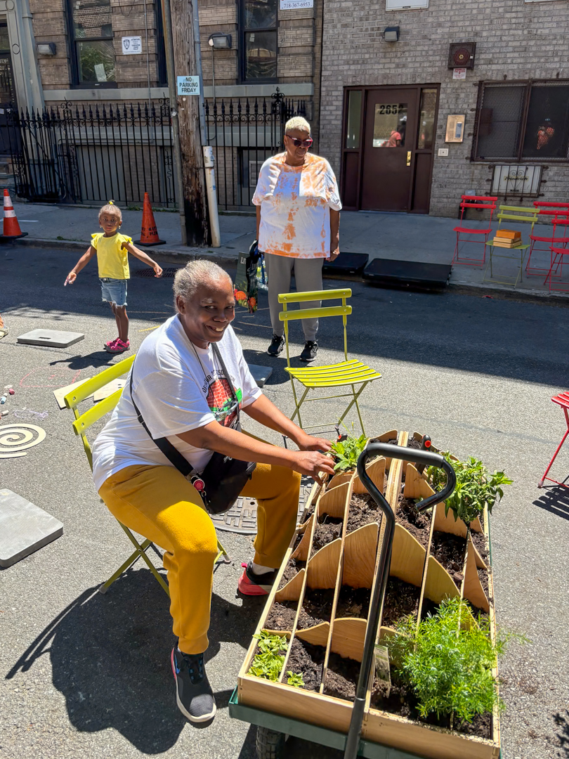 A older woman planting on the street.