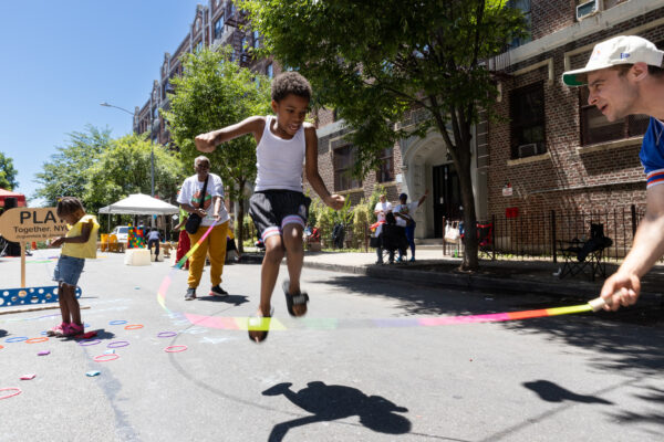Kids doing jump rope on the street.