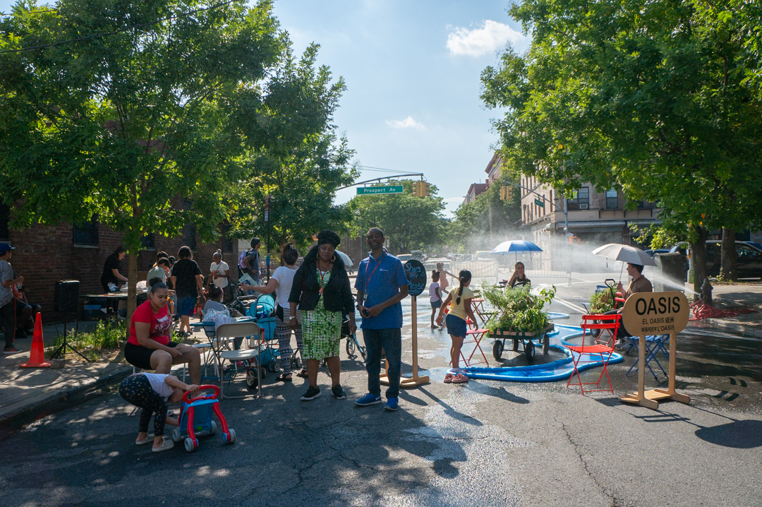 Adults and children hanging out on the street.