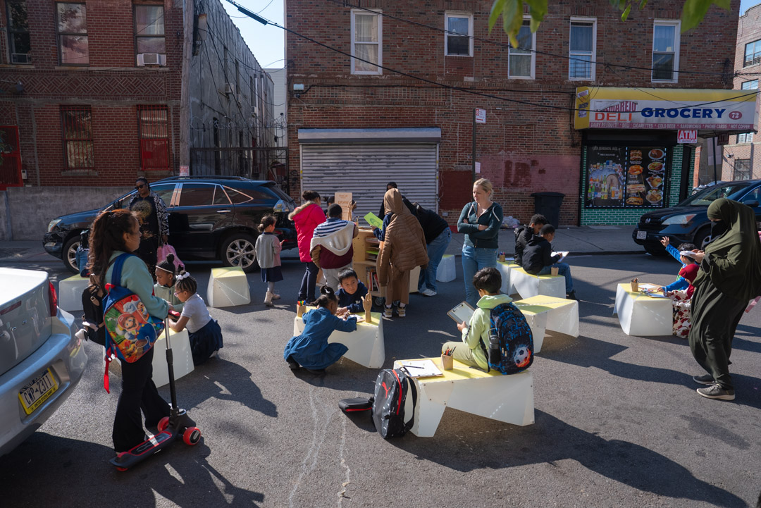 A view of adults and children spending time together on the street.